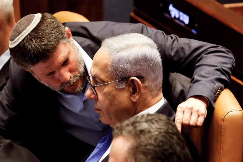 El gran promotor de la anexión de Cisjordania, el ultraderechista Bezalel Smotrich, habla al oído de Benjamin Netanyahu en la Knéset